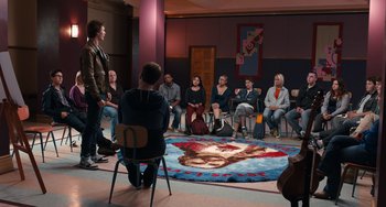 Movie still from “The Fault in Our Stars” (2014), directed by Josh Boone – A group of people sitting in a circle in front of a rug; Wide shot, High angle