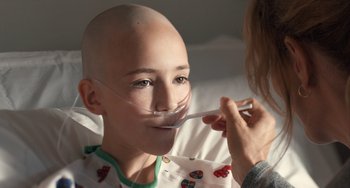 Movie still from “The Fault in Our Stars” (2014), directed by Josh Boone – A young boy is being examined by a nurse; Close Up shot, Over the shoulder angle