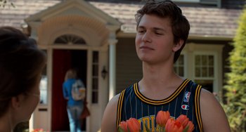 Movie still from “The Fault in Our Stars” (2014), directed by Josh Boone – A young man holding a bouquet of flowers in front of a house; Medium shot, Over the shoulder angle
