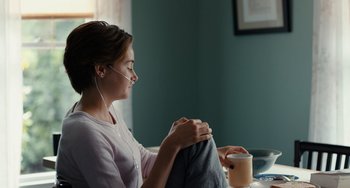 Movie still from “The Fault in Our Stars” (2014), directed by Josh Boone – A woman sitting at a table with a cup of coffee; Medium shot, Over the shoulder angle