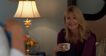 Movie still from “The Fault in Our Stars” (2014), directed by Josh Boone – A woman sitting at a table holding a coffee mug; Medium shot, Over the shoulder angle