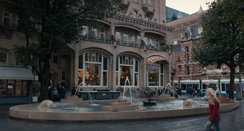 Movie still from “The Fault in Our Stars” (2014), directed by Josh Boone – A fountain in front of a building on a city street; Extreme Wide shot, Low angle