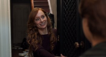 Movie still from “The Fault in Our Stars” (2014), directed by Josh Boone – A woman with long red curly hair smiling for the camera; Medium shot, Over the shoulder angle