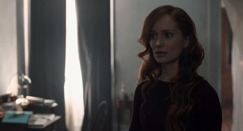 Movie still from “The Fault in Our Stars” (2014), directed by Josh Boone – A woman with long red curly hair standing in front of a window; Medium shot, Over the shoulder angle