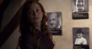 Movie still from “The Fault in Our Stars” (2014), directed by Josh Boone – A woman with long red hair standing in front of a picture; Close Up shot, Over the shoulder angle