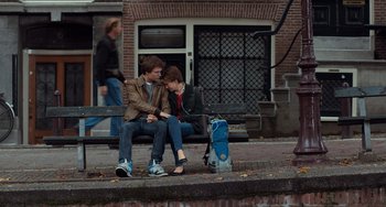 Movie still from “The Fault in Our Stars” (2014), directed by Josh Boone – Two young men sitting on a bench next to a suitcase; Wide shot, Over the shoulder angle