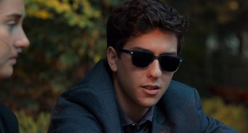Movie still from “The Fault in Our Stars” (2014), directed by Josh Boone – A young man wearing a suit and sunglasses; Close Up shot, Low angle