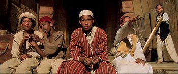 Movie still from “The Fifth Element” (1997), directed by Luc Besson – A group of men sitting on top of each other; Medium shot, Low angle