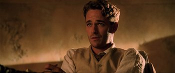 Movie still from “The Fifth Element” (1997), directed by Luc Besson – A person sitting in a room; Close Up shot, Over the shoulder angle