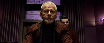 Movie still from “The Fifth Element” (1997), directed by Luc Besson – An older man wearing a brown jacket and a man wearing a black hat; Close Up shot, Low angle