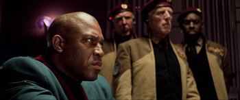 Movie still from “The Fifth Element” (1997), directed by Luc Besson – A group of men standing next to each other in a room; Close Up shot, Over the shoulder angle