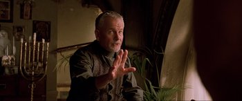 Movie still from “The Fifth Element” (1997), directed by Luc Besson – An older man sitting in front of a plant; Close Up shot, Over the shoulder angle