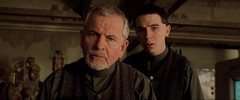 Movie still from “The Fifth Element” (1997), directed by Luc Besson – A man and a young man standing next to each other; Close Up shot, Low angle