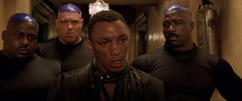 Movie still from “The Fifth Element” (1997), directed by Luc Besson – A group of men standing next to each other in a room; Close Up shot, Low angle