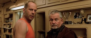 Movie still from “The Fifth Element” (1997), directed by Luc Besson – Two men standing next to each other in a room; Close Up shot, Low angle