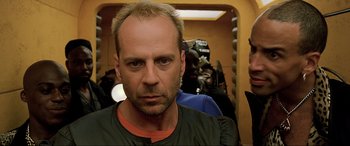 Movie still from “The Fifth Element” (1997), directed by Luc Besson – A person with a camera in a room; Close Up shot, Over the shoulder angle