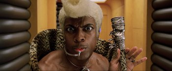 Movie still from “The Fifth Element” (1997), directed by Luc Besson – A man with a white wig holding a silver object; Close Up shot, Low angle
