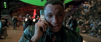 Movie still from “The Fifth Element” (1997), directed by Luc Besson – A man holding a cell phone up to his ear; Close Up shot, High angle