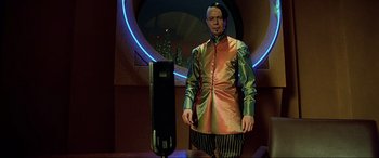 Movie still from “The Fifth Element” (1997), directed by Luc Besson – A man standing in front of a microphone in front of a mirror; Medium shot, Low angle