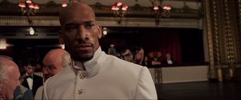 Movie still from “The Fifth Element” (1997), directed by Luc Besson – A person wearing a suit and tie; Close Up shot, Low angle