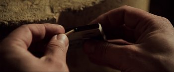 Movie still from “The Fifth Element” (1997), directed by Luc Besson – A person holding a piece of wood in their hand; Extreme Close Up shot, High angle