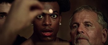 Movie still from “The Fifth Element” (1997), directed by Luc Besson – A person with a man in the background; Close Up shot, Low angle