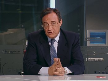 Movie still from “The Figo Affair: The Transfer that Changed Football” (2022), directed by Ben Nicholas – A man sitting at a table in front of a window; Medium shot, Low angle