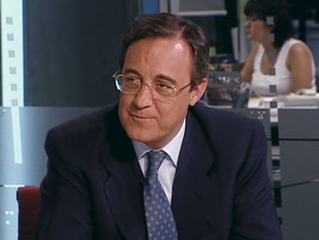 Movie still from “The Figo Affair: The Transfer that Changed Football” (2022), directed by Ben Nicholas – A person wearing a suit and tie; Close Up shot, Low angle
