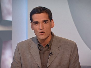 Movie still from “The Figo Affair: The Transfer that Changed Football” (2022), directed by Ben Nicholas – A man in a brown jacket and a brown shirt; Close Up shot, Low angle