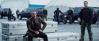 Movie still from “Deadpool” (2016), directed by Tim Miller – A man sitting on top of a white trunk; Medium shot, Low angle