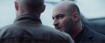 Movie still from “Deadpool” (2016), directed by Tim Miller – A man with a bald head is looking at another man with a bald head; Close Up shot, Over the shoulder angle