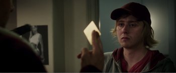 Movie still from “Deadpool” (2016), directed by Tim Miller – A person holding a piece of paper up to their face; Close Up shot, Over the shoulder angle