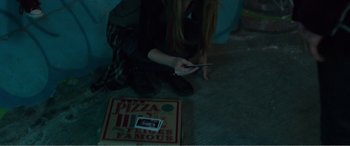 Movie still from “Deadpool” (2016), directed by Tim Miller – A woman sitting on the floor looking at her cell phone; Extreme Close Up shot, Overhead angle