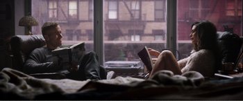 Movie still from “Deadpool” (2016), directed by Tim Miller – A man and a woman laying on a bed reading books; Wide shot, High angle