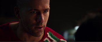 Movie still from “Deadpool” (2016), directed by Tim Miller – A person wearing a red and green shirt; Close Up shot, Over the shoulder angle