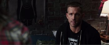 Movie still from “Deadpool” (2016), directed by Tim Miller – A person sitting in front of a brick wall; Close Up shot, Over the shoulder angle