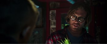 Movie still from “Deadpool” (2016), directed by Tim Miller – A man in a red plaid shirt is holding a plant; Close Up shot, Over the shoulder angle