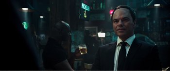 Movie still from “Deadpool” (2016), directed by Tim Miller – A man in a suit and tie holding a glass of beer; Close Up shot, Over the shoulder angle