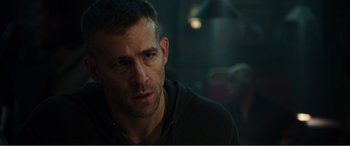Movie still from “Deadpool” (2016), directed by Tim Miller – A person wearing a black hoodie; Close Up shot, Over the shoulder angle