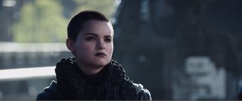Movie still from “Deadpool” (2016), directed by Tim Miller – A woman with a shaved head wearing a black scarf; Close Up shot, Low angle