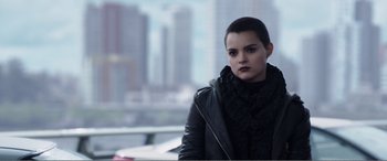 Movie still from “Deadpool” (2016), directed by Tim Miller – A woman in a black jacket is looking at the camera; Close Up shot, Over the shoulder angle