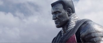 Movie still from “Deadpool” (2016), directed by Tim Miller – A statue of a man in a red and black outfit; Close Up shot, Low angle