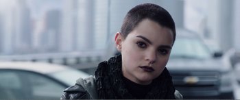 Movie still from “Deadpool” (2016), directed by Tim Miller – A woman with a shaved head wearing a black jacket; Close Up shot, Over the shoulder angle