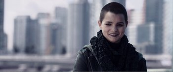 Movie still from “Deadpool” (2016), directed by Tim Miller – A woman with a shaved head smiles for the camera; Close Up shot, Over the shoulder angle