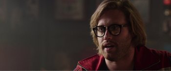 Movie still from “Deadpool” (2016), directed by Tim Miller – A person wearing glasses and a red jacket; Close Up shot, Over the shoulder angle