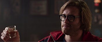 Movie still from “Deadpool” (2016), directed by Tim Miller – A person wearing glasses and a jacket; Close Up shot, Over the shoulder angle