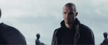 Movie still from “Deadpool” (2016), directed by Tim Miller – A man in a black jacket standing in front of a statue; Close Up shot, Low angle