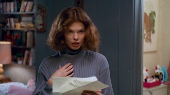 Movie still from “The Firm” (1993), directed by Sydney Pollack – A woman standing in front of a wall holding a piece of paper; Close Up shot, Low angle