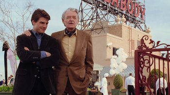 Movie still from “The Firm” (1993), directed by Sydney Pollack – Two men standing next to each other in front of a building; Medium shot, Over the shoulder angle