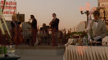 Movie still from “The Firm” (1993), directed by Sydney Pollack – A group of men playing musical instruments on a balcony; Extreme Wide shot, Low angle